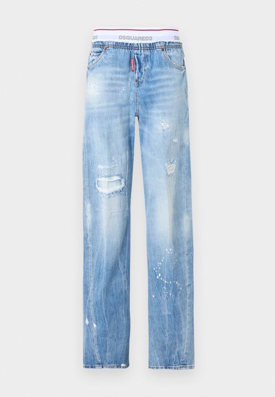 Ανοιχτό μπλε τζιν με φθορές, σχισμένο γόνατο, πιτσιλιές μπογιάς και λευκή ελαστική μέση με την ένδειξη DSQUARED2.