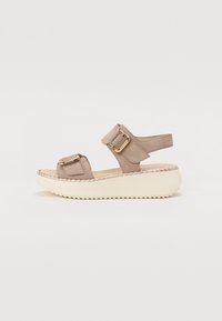 Beige syntetické sandály s dvěma nastavitelnými popruhy a zlatými kovovými doplňky na silné krémové podešvi s texturovaným vzorkem.