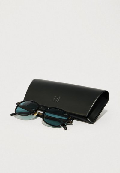 Fekete téglalap alakú napszemüveg zöld szűrővel rendelkező lencsékkel, arany részletekkel. Elegáns fekete bőr tok társaságában.