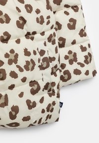 Dunjakke med en cremefarvet baggrund og brune leopardpletter, quiltet design og en lille lomme foran. Blød tekstur.