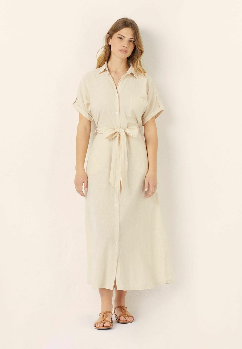 Abito button-up color beige chiaro con vita regolabile, maniche corte e lunghezza maxi. Presenta una sola tasca sul petto e una texture in lino morbido.