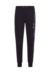 Schwarze Jogginghose mit elastischem Bund, Kordelzug und elastischen Bündchen an den Knöcheln. Mit weißem Logo-Text entlang der Seite. Weiche Stoffoberfläche.