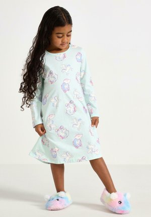 Jasnoniebieska nocna koszula z długim rękawem, ozdobiona fantazyjnym wzorem jednorożców i chmur; zestawiona z wielokolorowymi, puszystymi kapciami.