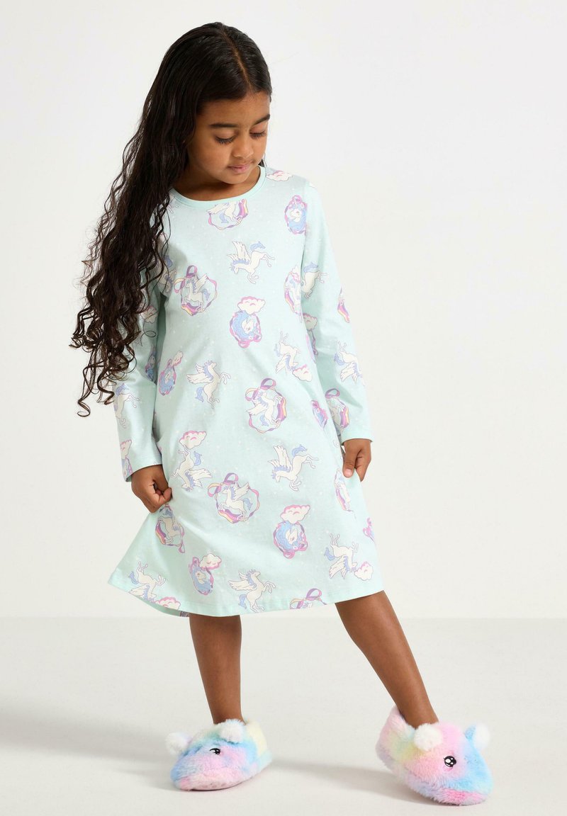 Hellblaues Nachthemd mit langen Ärmeln, das ein verspieltes Einhorn- und Wolkendesign zeigt; kombiniert mit bunten, flauschigen Hausschuhen.