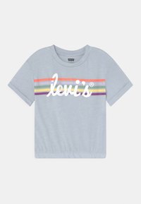 Jasnoniebieska skrócona koszulka z krótkim rękawem, wielokolorowe poziome paski i biały logo Levi's na wysokości klatki piersiowej.