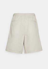 Shorts beige mi-longueur avec ceinture élastique et deux poches passepoilées à l'arrière, présentés sur un fond uni.