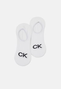 Bijele pamučne čarape bez prvog dela s elastičnim otvaranjem i crnim "CK" logotipom izvezenim sa strane. Meka tekstura i dizajn niskog kroja.