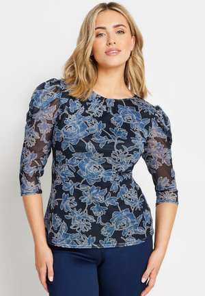 Blue floral blouse with sheer sleeves, featuring a round neckline and puffed shoulders. The pattern includes light blue flowers on a dark background.