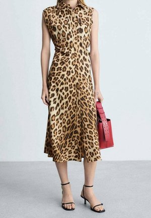 Sleeveless leopard print midi dress with button front, worn with black strappy heels and holding a red handbag.