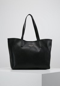 Sac fourre-tout Guess en cuir noir texturé avec deux poign ées et logo argenté centré à l'avant.