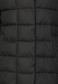 Black puffer jacket featuring a quilted design with rectangular sections, smooth texture, and a subtle brand label in the seam.