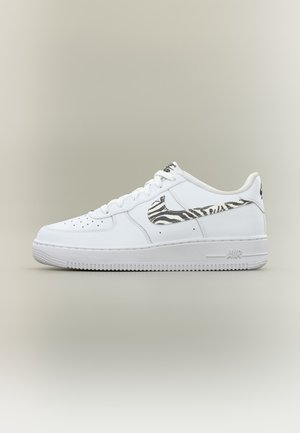 Biely nízky teniska s čierno-bielym zebrovým vzorom Nike Swoosh, perforovanou špičkou a nápisom "AIR" vyrazeným na podrážke.