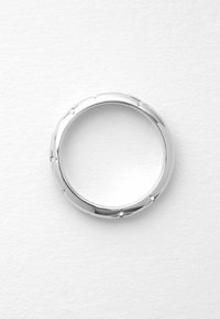 Silberner Ring mit einem glatten, abgerundeten Design, das subtile, strukturierte Akzente und kleine, diamantähnliche Details aufweist, die gleichmäßig um den Ring verteilt sind.