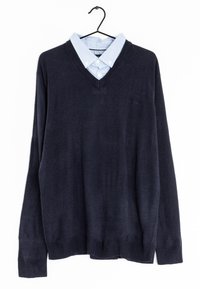 Navy knit sweater with a V-neck, layered over a light blue striped button-up shirt, featuring a collar and classic buttons.