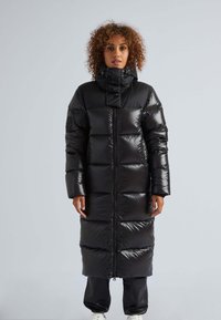 Abrigo de plumas largo y negro con un cuello alto, patrón acolchado, cierre de cremallera frontal y una textura brillante y suave.