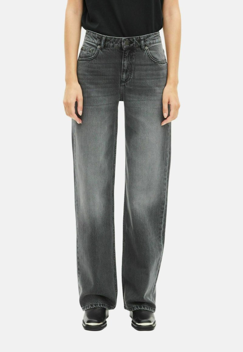 Pantalones vaqueros de pierna ancha en denim gris oscuro con un acabado deslavado. Presentan bolsillos frontales, un cierre de botón clásico y detalles de costura en contraste.