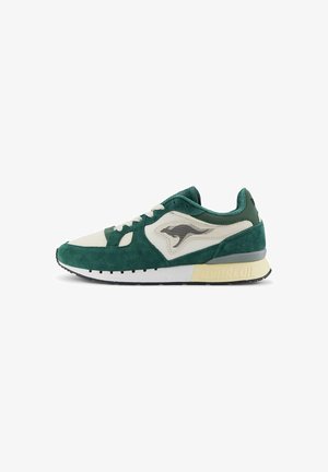Groene en crèmekleurige suède sneakers met een bovenwerk van mesh, zwart logo op de zijkant, witte tussenzool en een getextureerde rubberen buitenzool.