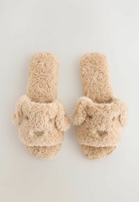 Beige pehmeät tossut, joissa on karvainen pinta, sisältäen suloinen eläin касвикuvio, pyöreä muoto ja pehmeät korvaaccentit sivuilla.