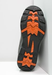 Schwarze Gummischuhsohle mit ausgeprägten Profil und orangefarbigen Akzenten, die ein Zickzackmuster aufweist und mit flexiblen Zonen für besseren Halt gekennzeichnet ist.