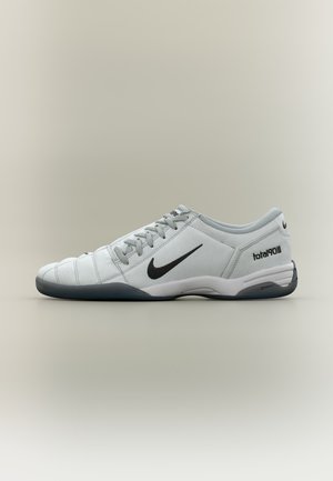 Chaussure de football basse Nike blanche et grise avec logo swoosh noir, lacets et texte « total90 III » sur le talon, vue de profil.