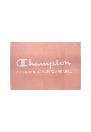 Asciugamano rettangolare rosa con logo bianco Champion e testo "Authentic Athletic Apparel" al centro.