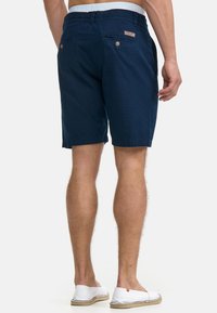 Granatowe szorty wykonane z bawełny, z dwoma tylnymi kieszeniami z zapięciem na guziki oraz logiem na pasku. Gładka tekstura i casualowy krój.