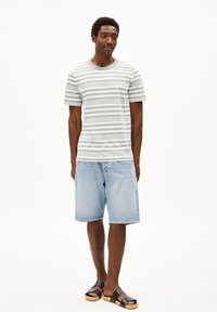 Gestreepte grijs-witte katoenen t-shirt, denim korte broek en zwarte sandalen. Casual pasvorm met korte mouwen en relaxte shorts.