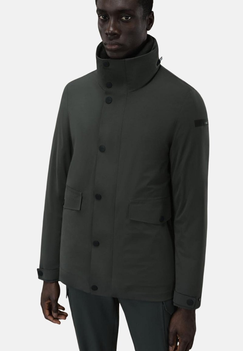 Giacca impermeabile grigio scuro con colletto alto, bottoni neri, due tasche frontali e un design elegante. Stile minimalista con una vestibilità moderna.