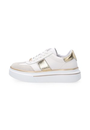 Hvid lavt sneakersko med gyldne metalliske detaljer, beige ruskindstodhætte, tyk hvid sål og hvide snørebånd, vist fra siden på en hvid baggrund.