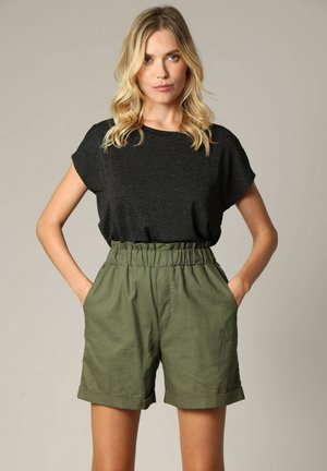 Haut à manches courtes rayé noir associé à un short taille haute vert olive. Le short présente une taille élastique et des poches latérales.