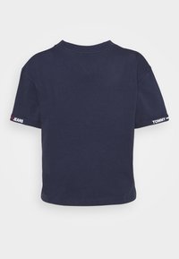 Mörkblå T-shirt i bomull med korta ärmar. Märkestexten "TOMMY" och "JEANS" i vitt på ärmsluten. Standard rund hals.