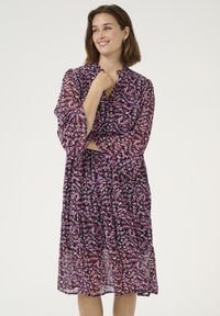 Purple floral mid-length dress with a V-neck, long sleeves, and tiered design. Lightweight, flowing fabric with a textured finish.