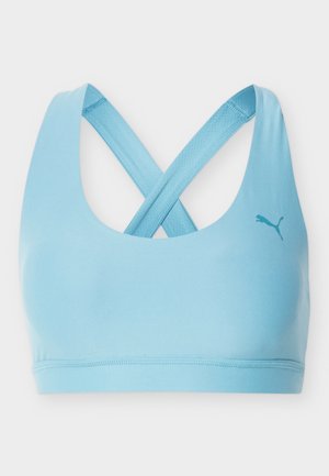 Športni modrček svetlo modre barve s prekrižanimi naramnicami na hrbtu in majhnim logotipom Pume na desni sprednji strani.