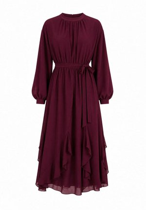 Robe bordeaux à manches longues avec taille froncée nouée par un nœud, col rond haut et ourlet asymétrique à volants.