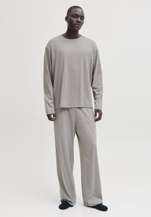 Graues Langarm-T-Shirt und passende, lockere Hose aus weichem Stoff. Das Outfit zeichnet sich durch eine entspannte Silhouette mit minimalen Nähten aus.
