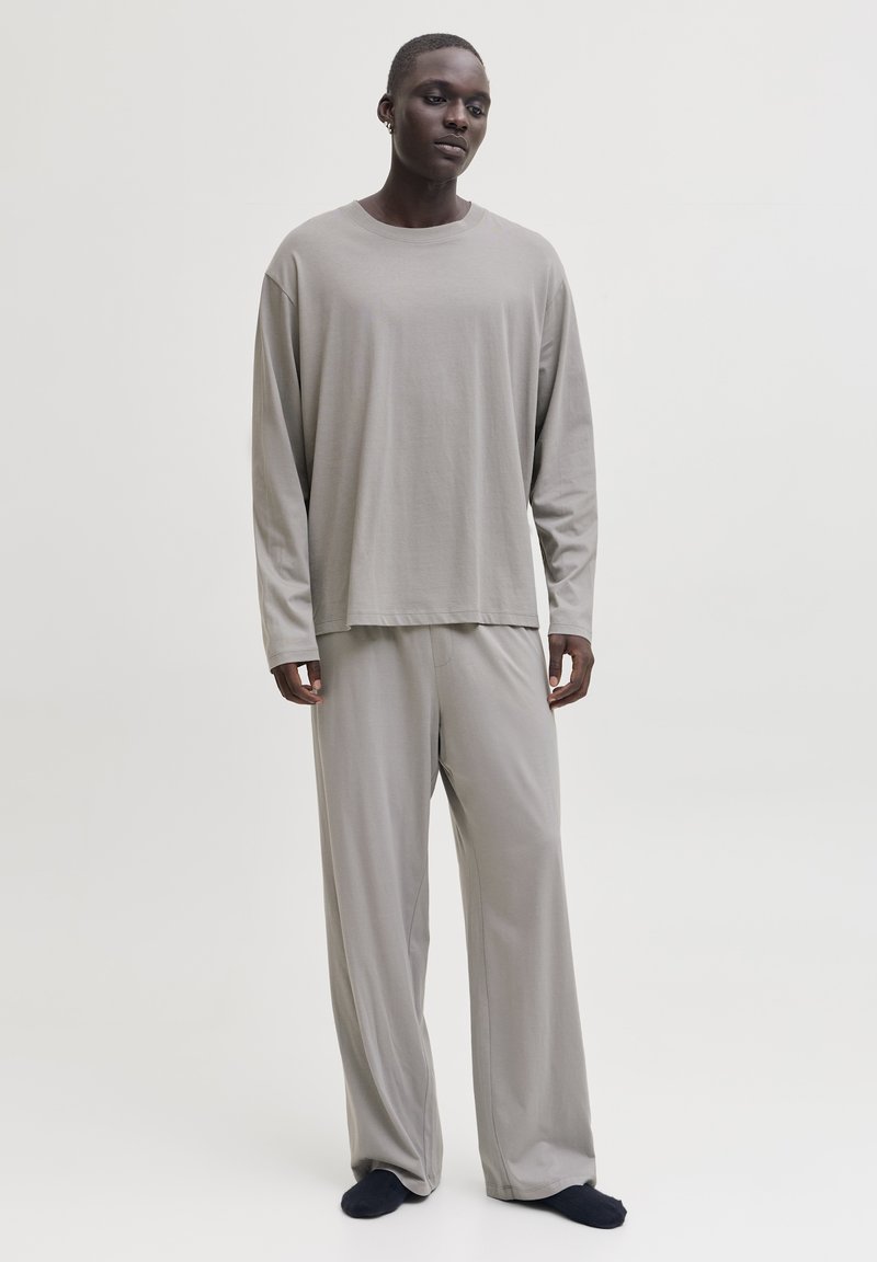 Grey long-sleeve t-shirt and matching loose-fitting pants in soft fabric. The outfit features a relaxed silhouette with minimal seams.