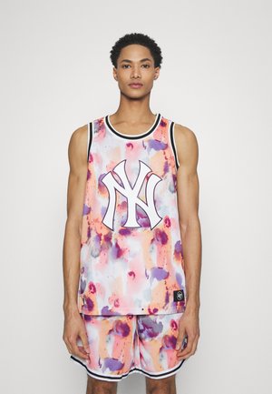 Conjunto de camiseta y pantalones cortos de baloncesto multicolor con patrones abstractos, que presenta un logotipo prominente en el centro, hecho de tejido ligero.