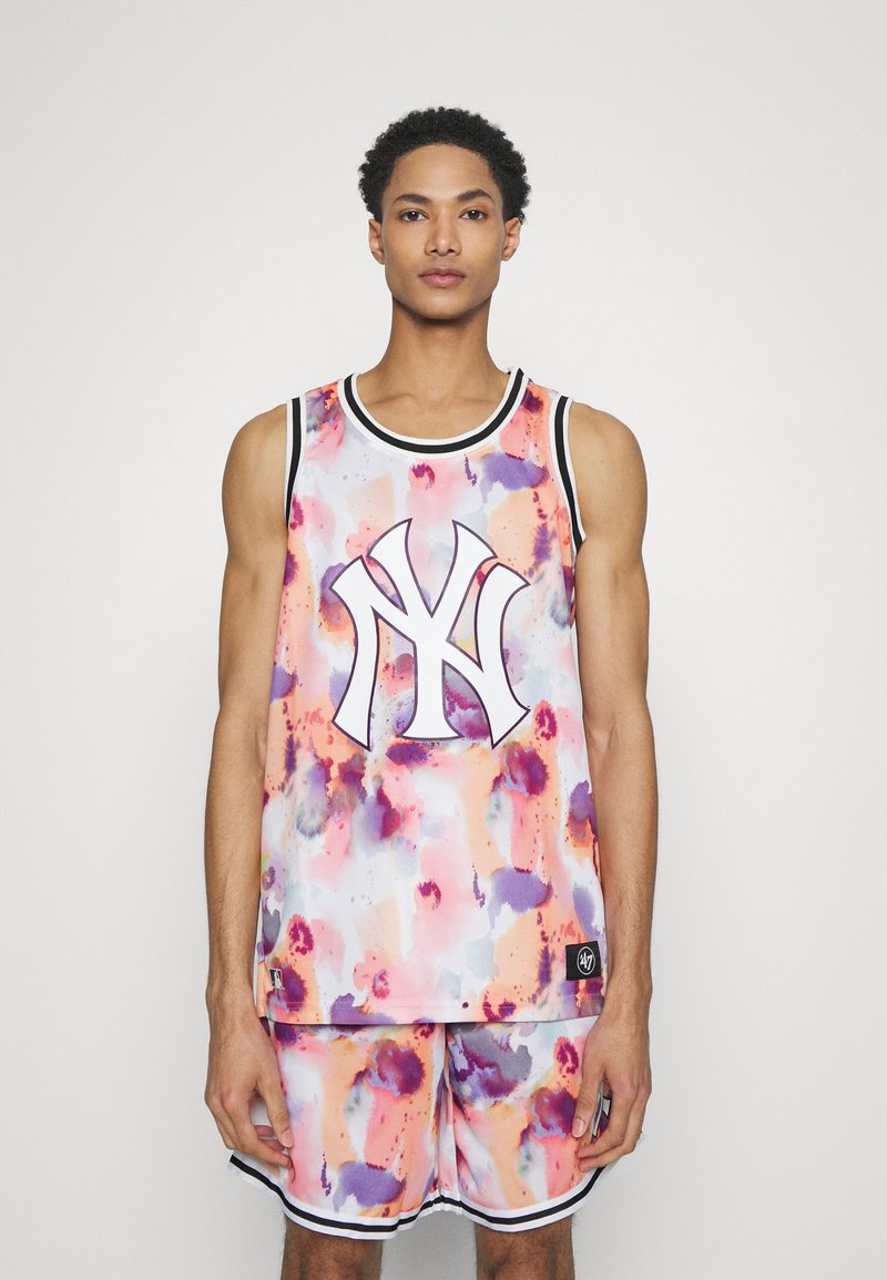Conjunto de camiseta y pantalones cortos de baloncesto multicolor con patrones abstractos, que presenta un logotipo prominente en el centro, hecho de tejido ligero.