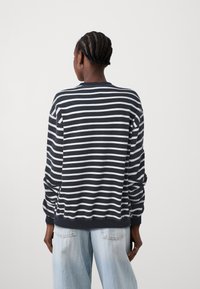 Felpa a maniche lunghe a righe blu navy e bianche, con polsini e orlo a coste, dotata di collo rotondo e vestibilità comoda, realizzata in tessuto morbido.