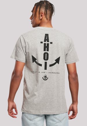 Grijze katoenen t-shirt met zwarte tekst "AHOI" met pijlen en een grafisch logo op de achterkant, korte mouwen en een losse pasvorm.