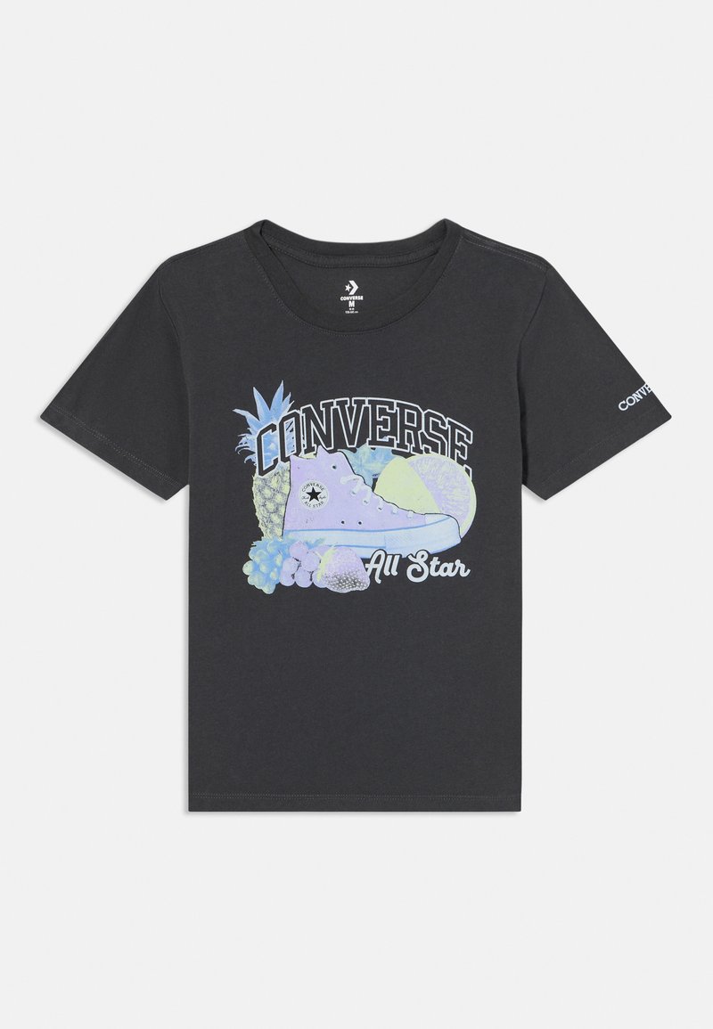 Must have mustelase keesi must tavate mustav t-särk, millel on värviline grafika Converse'i kingast ja puuviljast, ning "CONVERSE All Star" tekst julgete valgete tähtedega.