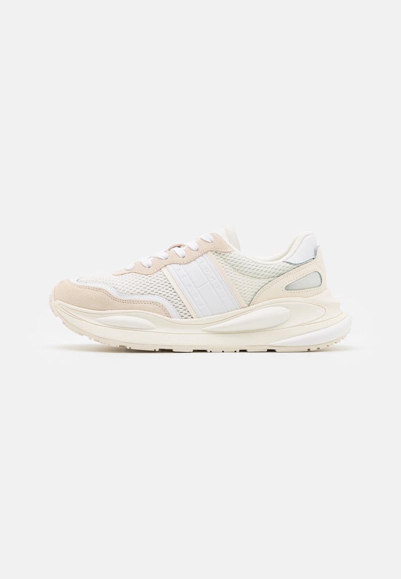 White and beige athletic sneaker with mesh panels, textured accents, a cushioned sole, and contrasting light blue details on the heel.