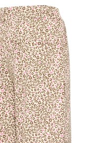 Gros plan sur un pantalon beige avec un petit imprimé floral marron et rose et une poche plaquée arrière du côté droit.