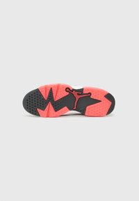 Mustade ja punaste sneakerite välistald tekstuursete mustritega, millel on silmapaistev Jumpman logo. Lame, taktiilne pind haarde jaoks.