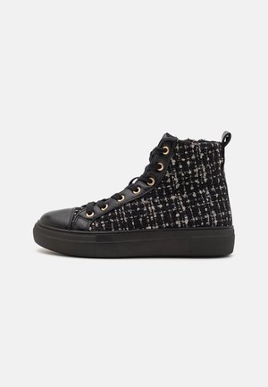 Sort høj top sneaker med tweedstof-sider, sorte snørebånd, guld øjer og en tyk gummisål mod en ensfarvet baggrund.