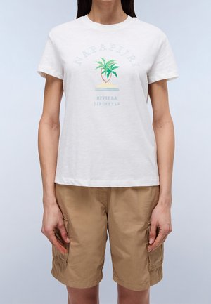 Persoon draagt een wit T-shirt met korte mouwen met een palmboom en de tekst "Napapijri Riviera Lifestyle", gecombineerd met beige cargoshorts.