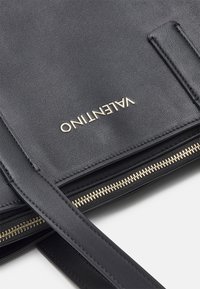Borsa a tracolla in pelle nera con zip dorata e logo Valentino in metallo dorato sulla patta frontale testurizzata.