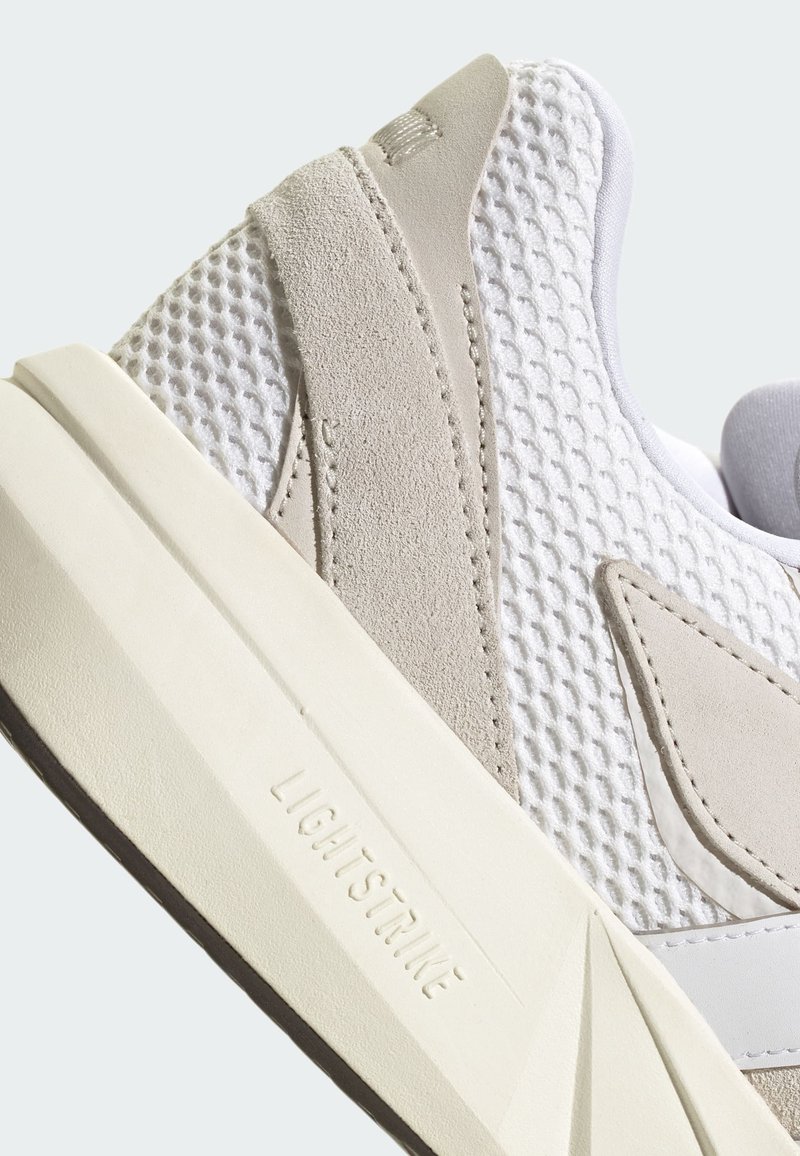 Weiße Mesh- und beigefarbene Wildledersneaker mit einer strukturierten Oberfläche und einer ausgeprägten Sohle, die mit "LIGHTSTRIKE" gekennzeichnet ist. Verfügt über ein tief geschnittenes Design.