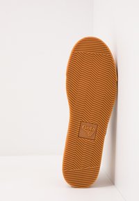 Suola di scarpa in gomma arancione, caratterizzata da un motivo di trazione a zigzag e da un logo Gola quadrato. Testurizzata per una migliore aderenza e design flessibile.