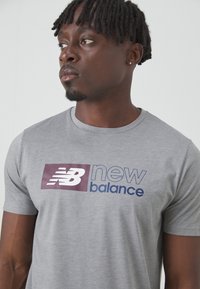 New Balance SPORT ESSENTIALS HEATHERTECH GRAPHIC  - T-shirts med print - slate grey